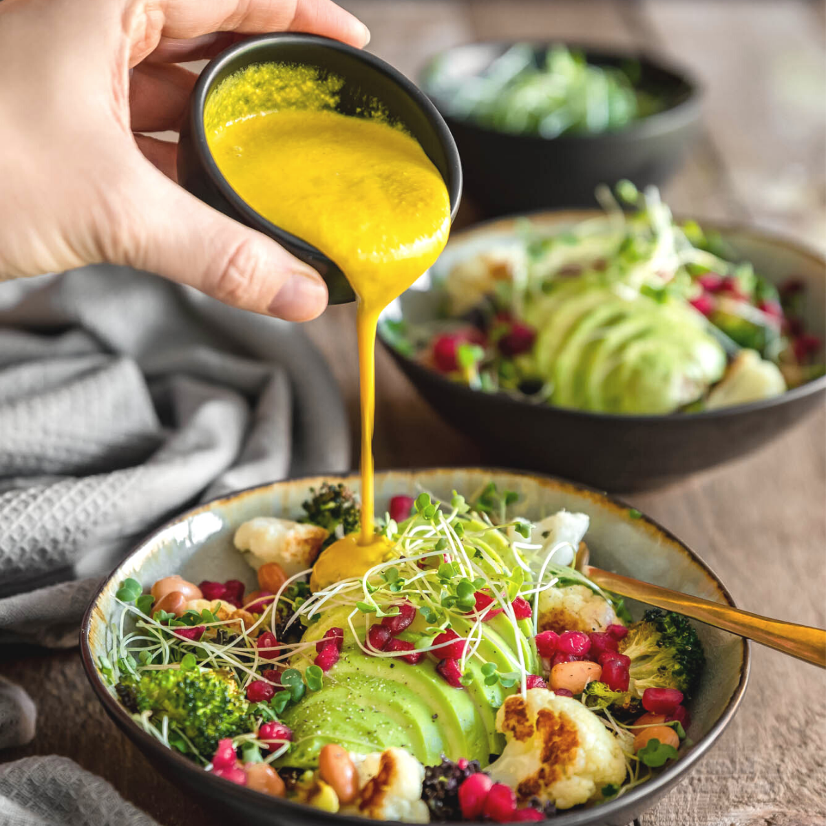 Pouring Mother Raw Vegan Lemon Tahini on a buddha bowl