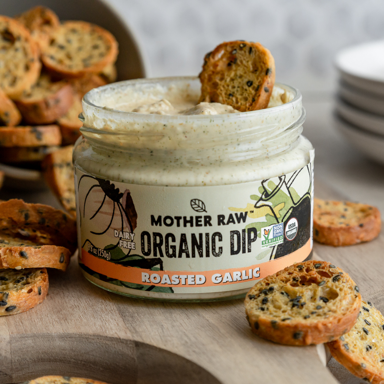 Crostini being dipped into Mother Raw Organic Dairy Free Everything Bagel Dip 